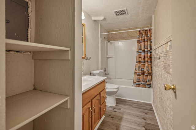 337 North Main Street Central Valley, UT 84754 - Photo 33 of 40 Full bathroom featuring vanity, shower / bathtub combination with curtain, light wood finished floors, a textured ceiling, and a textured wall