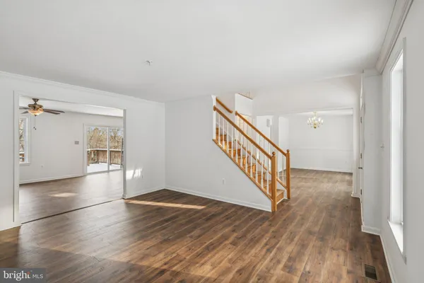 a view of a hallway with wooden floor and staircase