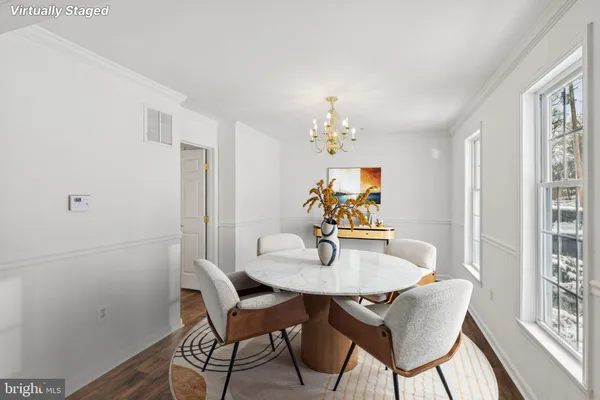 a dining room with furniture a rug and a mirror