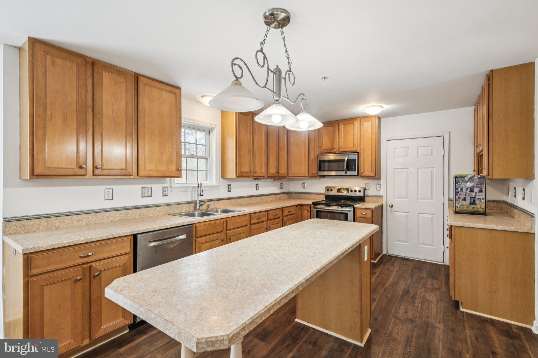 205 Captain Brendt Drive Accokeek, MD 20607 - Photo 8 of 37 a kitchen with wooden floors and wooden cabinets