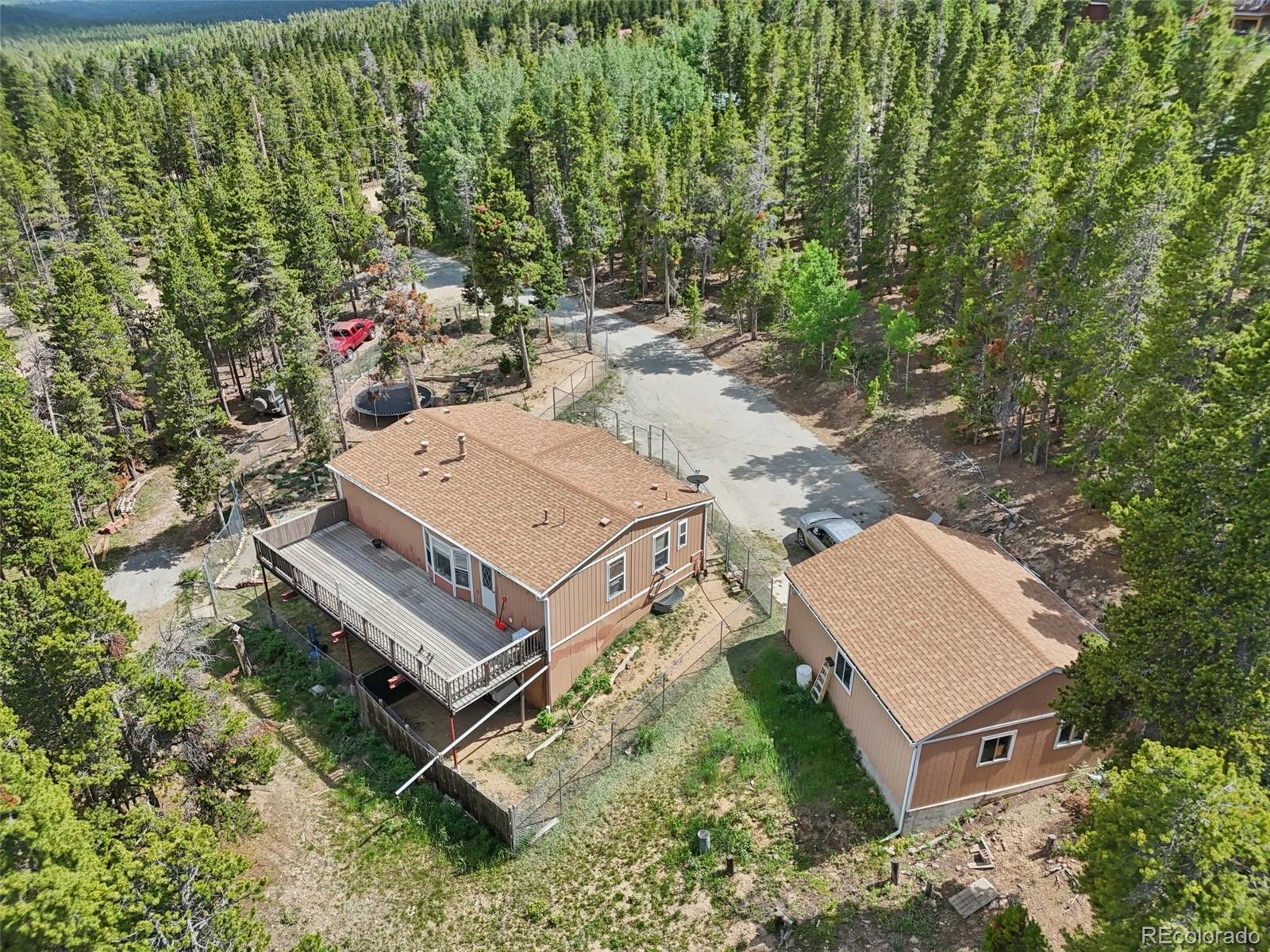 81 Atlantis Road Black Hawk, CO 80422 - Photo 1 of 40 an aerial view of a house with a yard and large trees