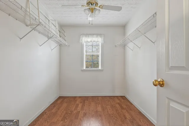 a view of a hallway with a window and wooden floor