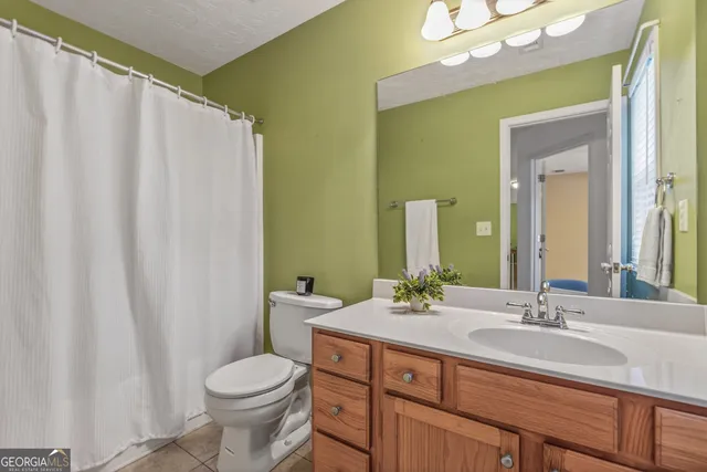 a bathroom with a double vanity sink toilet and a mirror