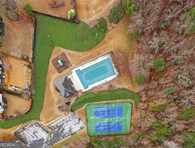 an aerial view of a house with a yard and wooden fence