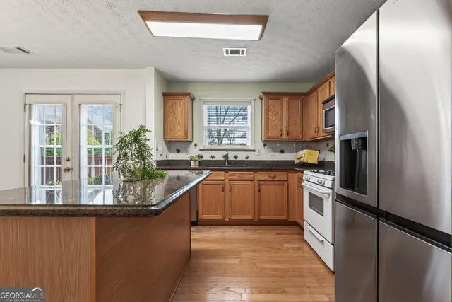a kitchen with stainless steel appliances granite countertop a refrigerator and a sink
