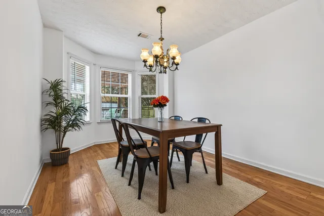 a dining room with furniture potted plants and wooden floor