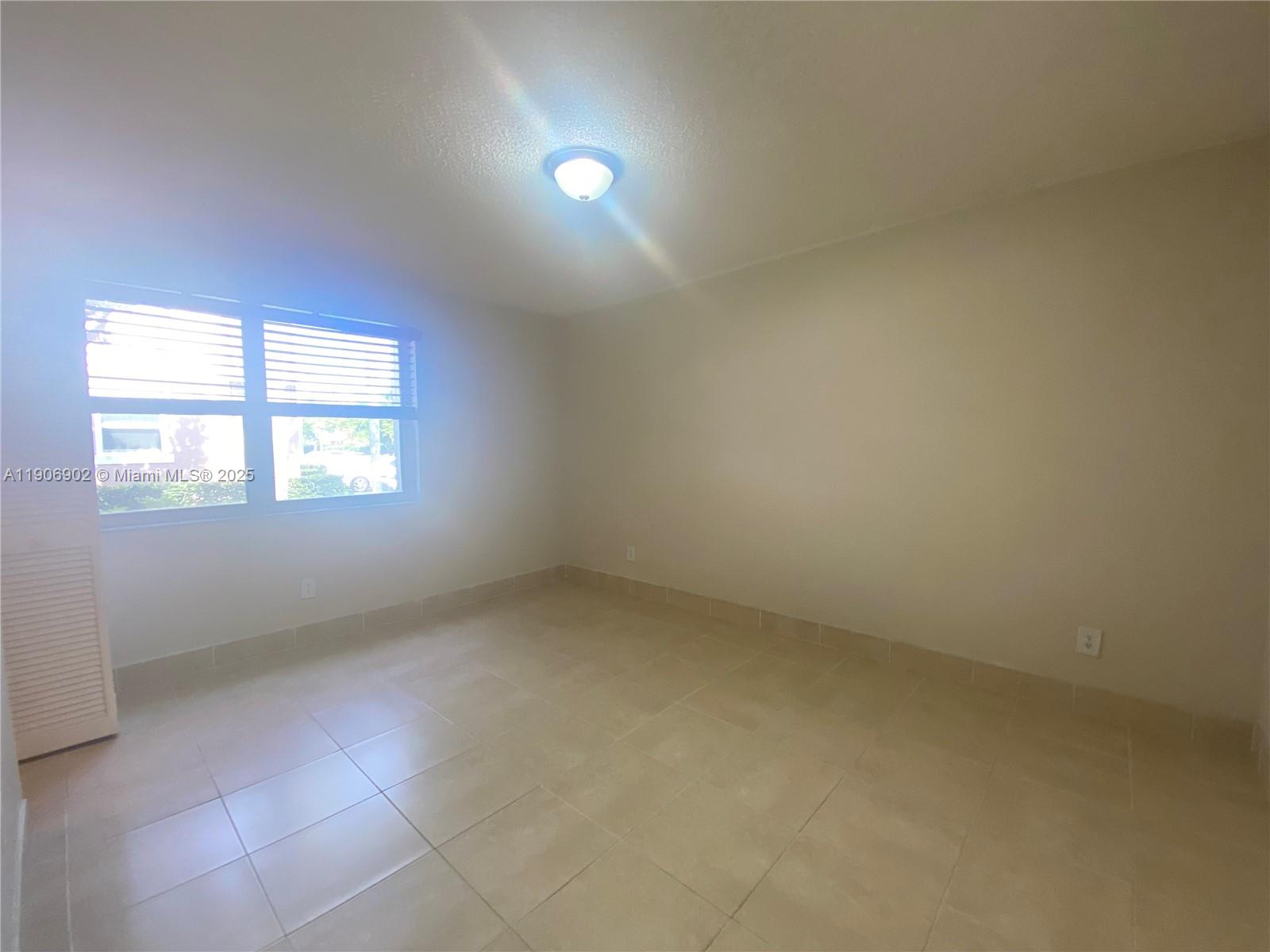 11232 Southwest 12th Street, Unit 101 Pembroke Pines, FL 33025 - Photo 11 of 37 an empty room with a window
