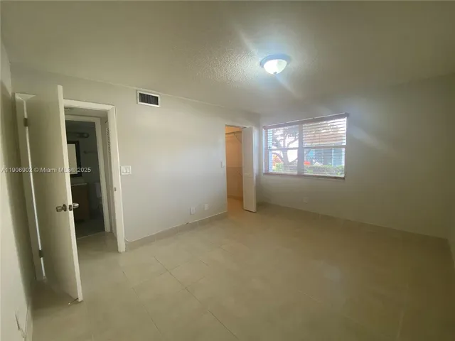 an empty room with windows and closet