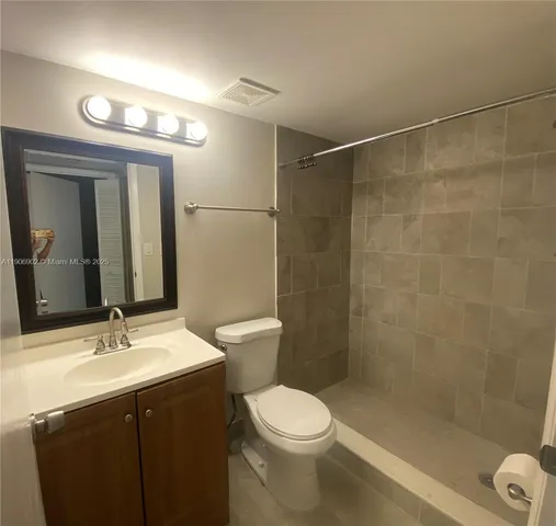 a bathroom with a sink mirror vanity and toilet