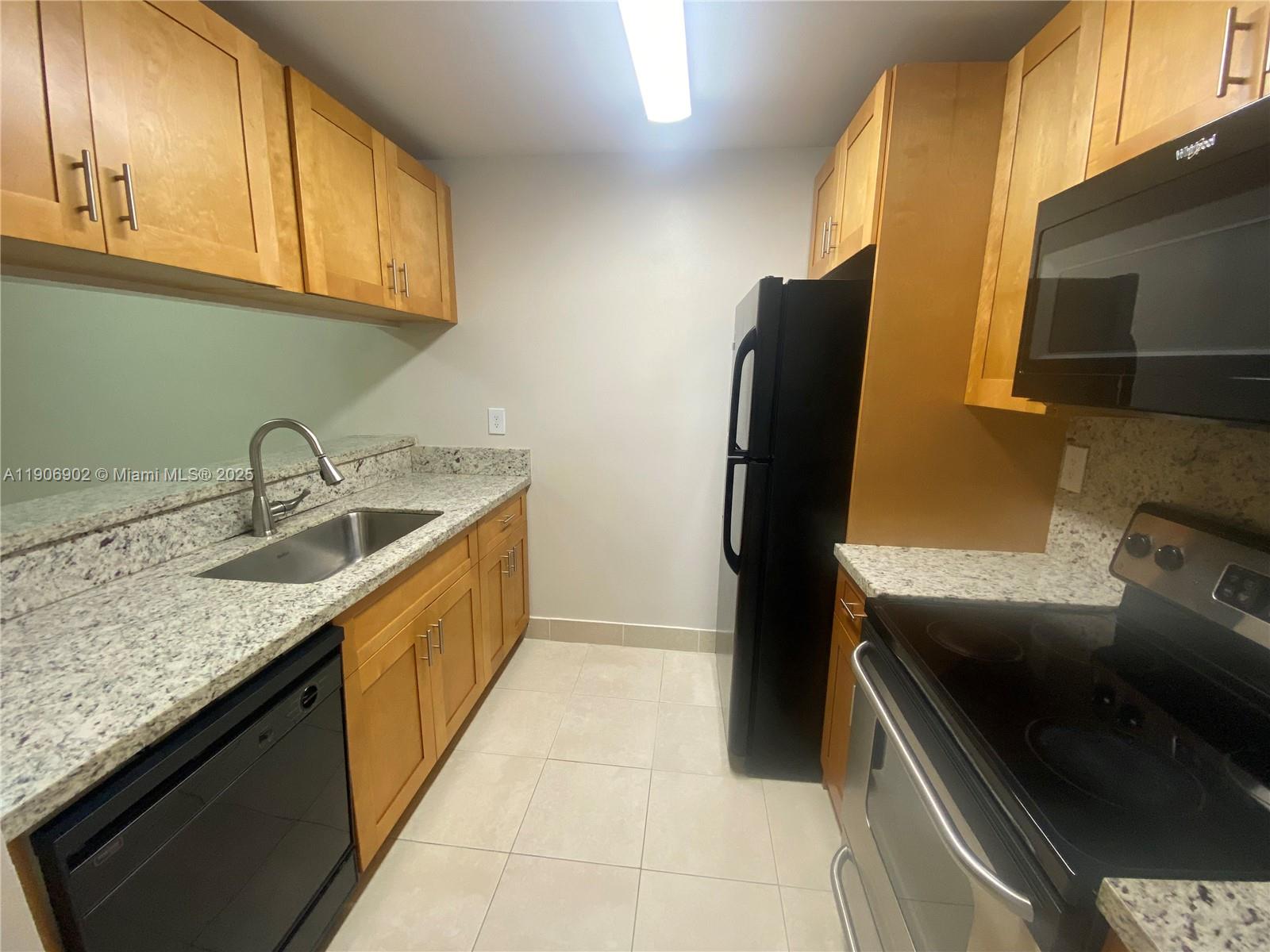 11232 Southwest 12th Street, Unit 101 Pembroke Pines, FL 33025 - Photo 2 of 37 a kitchen with granite countertop a sink a stove and refrigerator