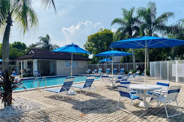 a patio with a table and chairs under an umbrella