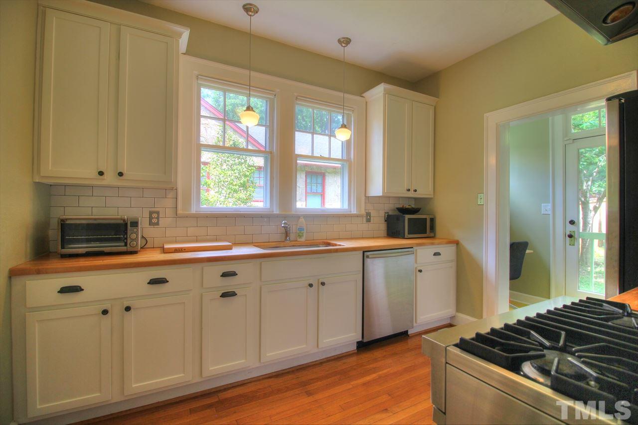 500 Harvey Street Raleigh, NC 27608 - Photo 7 of 26 a kitchen with a sink stove and cabinets