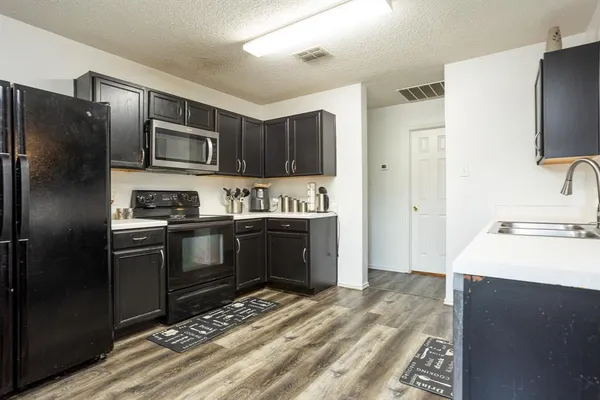 a kitchen with granite countertop a refrigerator and a sink