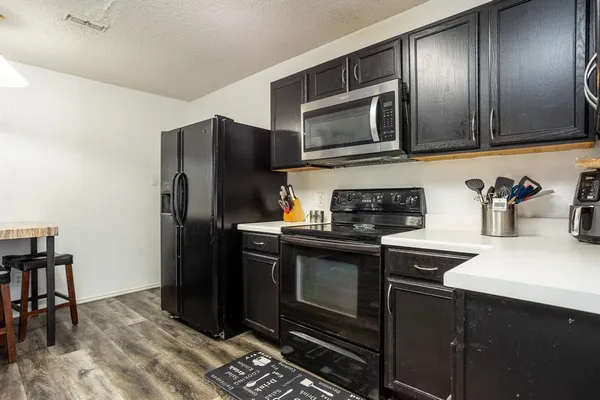 a kitchen with stainless steel appliances granite countertop a refrigerator stove and microwave