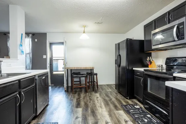 a kitchen with stainless steel appliances a stove refrigerator sink and cabinets