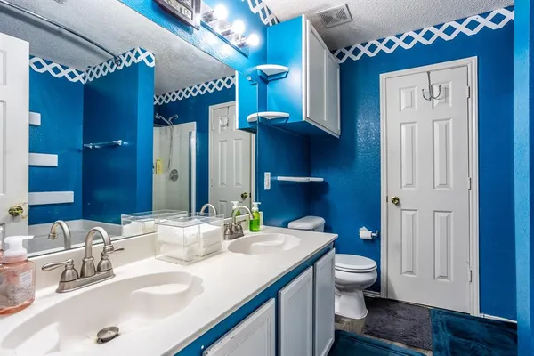 a bathroom with a double vanity sink mirror and toilet