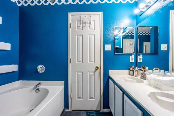a bathroom with a tub sink and mirror