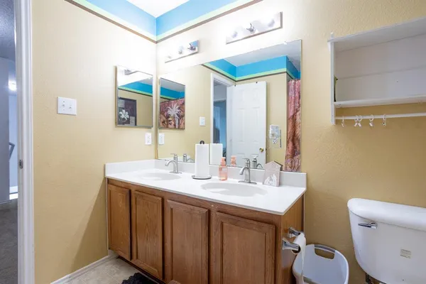 a bathroom with a sink vanity mirror and toilet