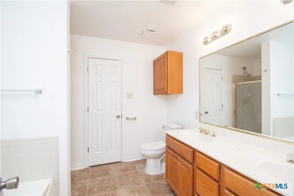 a spacious bathroom with a granite countertop sink mirror and a toilet