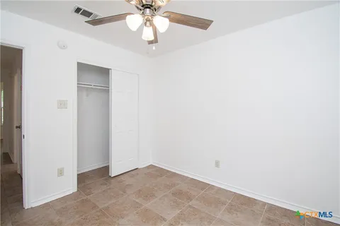 an empty room with a chandelier fan and a chandelier fan