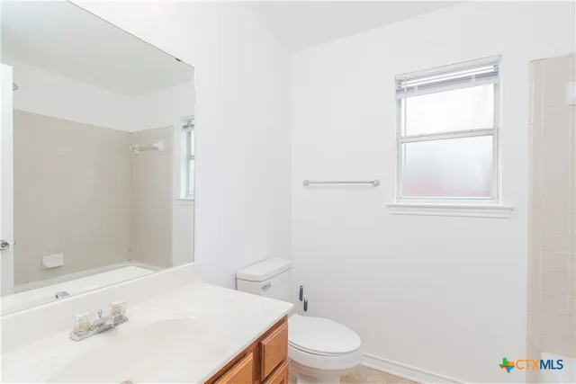 a white toilet sitting next to a bathroom sink
