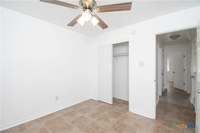 an empty room with a fan and a fan