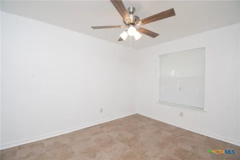 an empty room with a chandelier fan