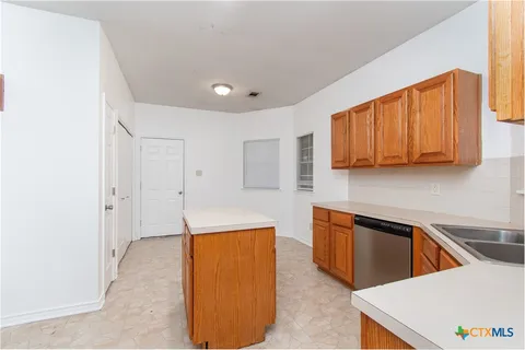 a view of a kitchen with stainless steel appliances granite countertop a sink and a refrigerator