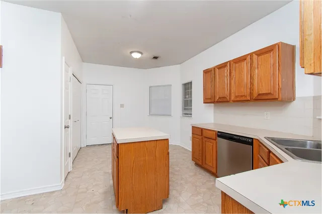 a view of a kitchen with stainless steel appliances granite countertop a sink and a refrigerator