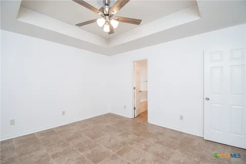 an empty room with a chandelier fan and closet