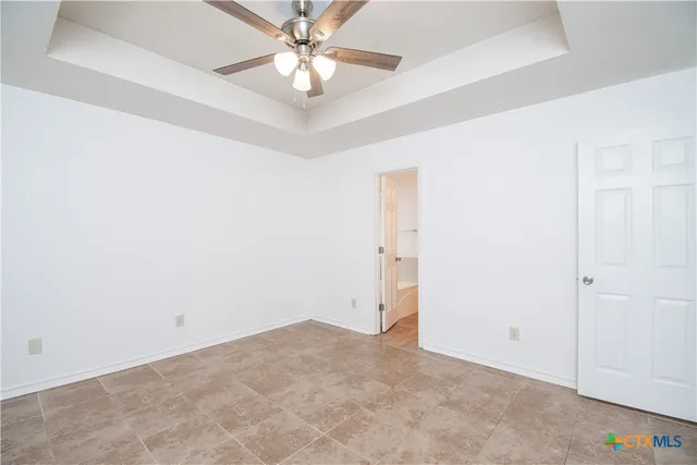 an empty room with a chandelier fan and closet