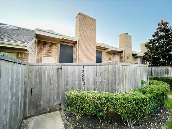 a view of a house with a door and wooden bench