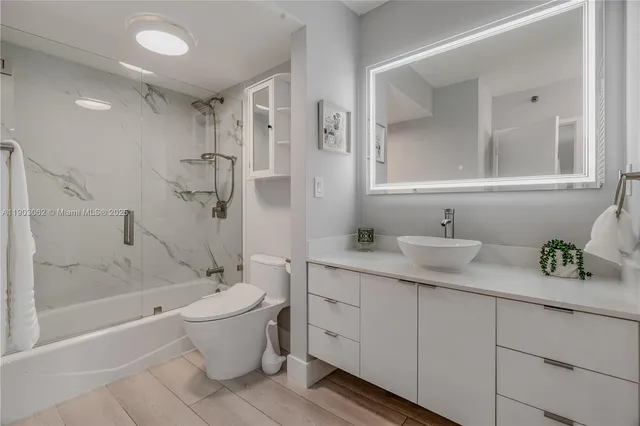 a kitchen with a sink a refrigerator and white cabinets
