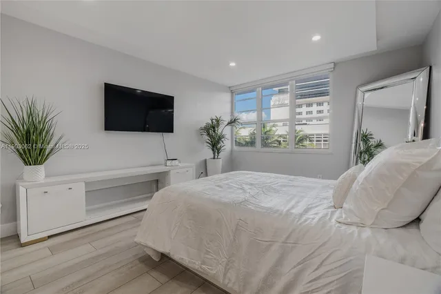 a view of a tall white building next to a yard