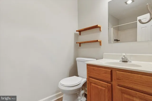 a bathroom with a granite countertop toilet sink and mirror