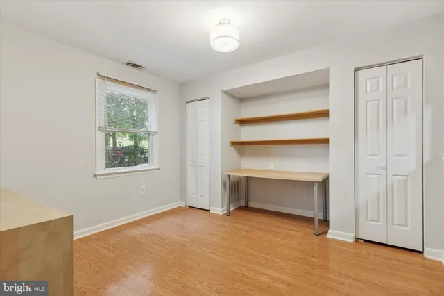 a view of an empty room with a fireplace and a window