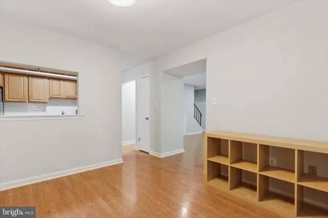 a view of an empty room with wooden floor and cabinet