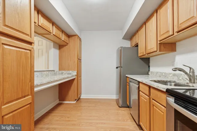 a kitchen with granite countertop a sink and a refrigerator