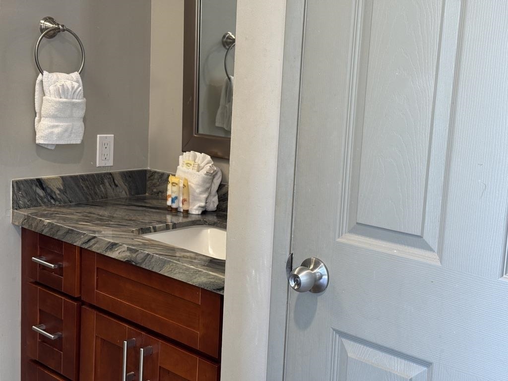 4327 Lower Honoapiilani Road, Unit 201B Lahaina, HI 96761 - Photo 13 of 26 a bathroom with a granite countertop sink and a mirror