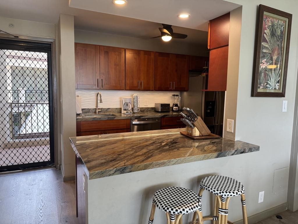 4327 Lower Honoapiilani Road, Unit 201B Lahaina, HI 96761 - Photo 6 of 26 a kitchen with a sink a stove and cabinets