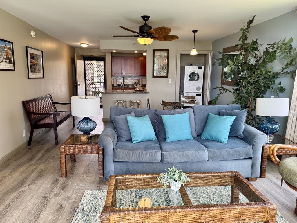 4327 Lower Honoapiilani Road, Unit 201B Lahaina, HI 96761 - Photo 8 of 26 a living room with furniture a chandelier and a dining table