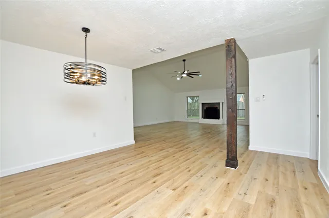 a view of empty room with wooden floor and window