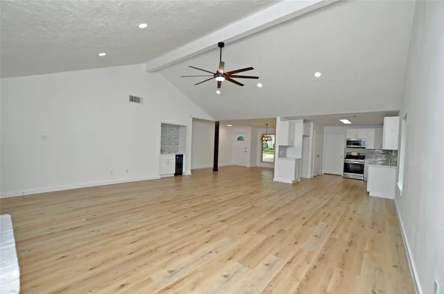 a view of empty room with wooden floor and ceiling fan