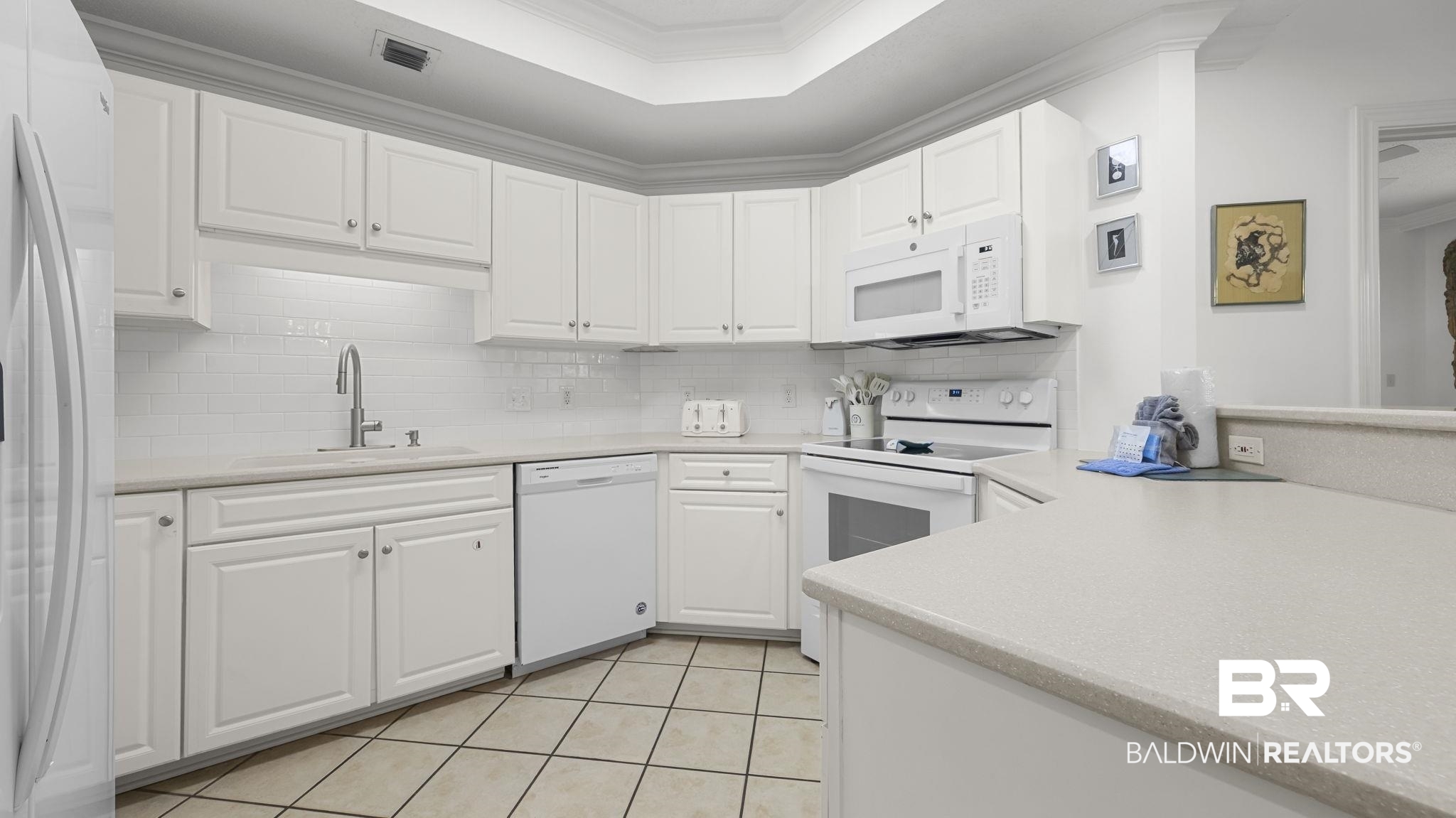 27580 Canal Road, Unit 1213 Orange Beach, AL 36561 - Photo 6 of 27 Kitchen featuring white cabinetry, light-toned countertops, white subway tile backsplash, and coordinating white appliances