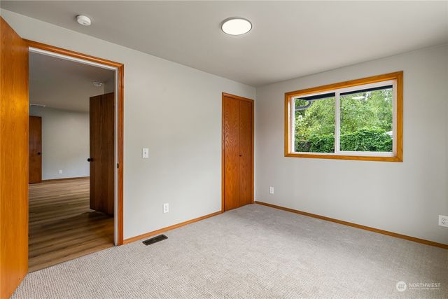 an empty room with windows and closet