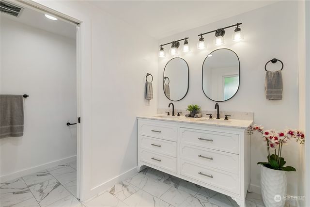 a bathroom with a double vanity sink and a mirror