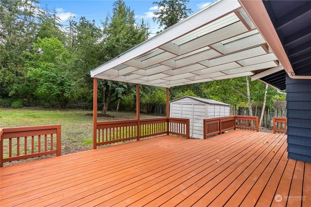 a view of backyard with deck and outdoor seating