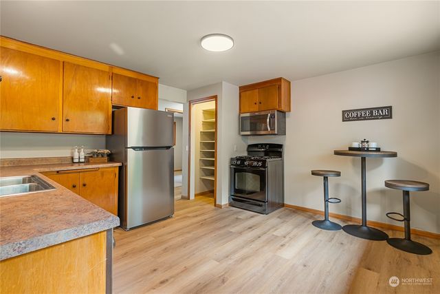 a kitchen with stainless steel appliances granite countertop a refrigerator and a stove top oven