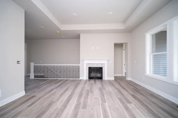 a view of empty room with wooden floor and fireplace