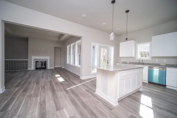 a large kitchen with kitchen island white cabinets and stainless steel appliances